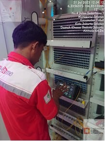 Teknisi melakukan pengujian pada rack distribusi jaringan
